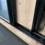 Kleiderschrank Mina mit Schiebetüren in Weiß/Schwarz gehalten, moderne Optik, Lamellen in Eichen Optik, Anti Staubbürsten, 235,2 x 110 x 60 cm, robust